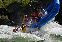 rafting by Ron Niebrugge: white water rafting, with the raft tipped up and half the people going into the water, photo used with permission from the photographer Ron Niebrugge