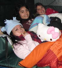 3 girls in tent 2011 winter: 3 girls in a tent in their sleeping bags, wearing knit hats