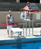 Alanna Klassen and Ethan Wilkie rotate guarding stations 1: one lifeguard at deck level, one in the lifeguard stand
