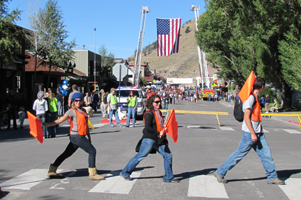 Old Bill's Fun Run volunteers Alanna Klassen, Emily Kinner and Alex Mitchell: three people crossing a crosswalk wearing orange vests, carrying flags