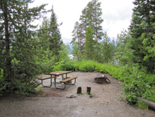 campsite at Signal Mountain: campsite with picnic table and firering, surrounded by trees, lake slightly visible in background