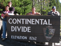 continental divide 2010 photo by Mark Nevill: four people stand behind sign that says continental divide
