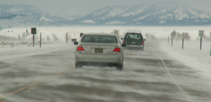 teton road with blowing snow: teton road with two cars and blowing snow