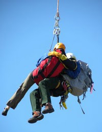 Guides Wall Rescue NPS photo: park ranger and victim being rescued hang from a cable