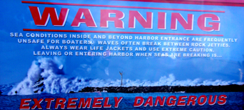 Morro Bay Harbor warning sign: Morro Bay Harbor warning sign with photo of a large boat caught in an even bigger wave at the entrance to the harbor.