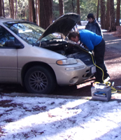 Richard Webster works on Ethan's car Yosemite 2016: a man at the open engine compartment of a Buick, with a battery on the ground in the snow