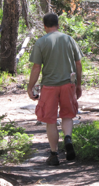 String Lake hiker with diet soda: a man off on a hike, in hiking boots, shorts and a t-shirt, carrying a half liter of diet soda and not much else