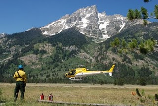 Teton interagency helicopter NPS photo: helicopter lifts off with Teton mountains in background