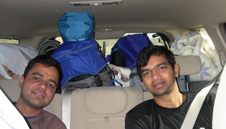 carpool brad and gear to ceiling.jpg: car interior with two passengers in backseat and gear piled to the ceiling