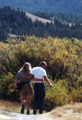 couple on tetons trail: couple walking together on a trail with hills in background