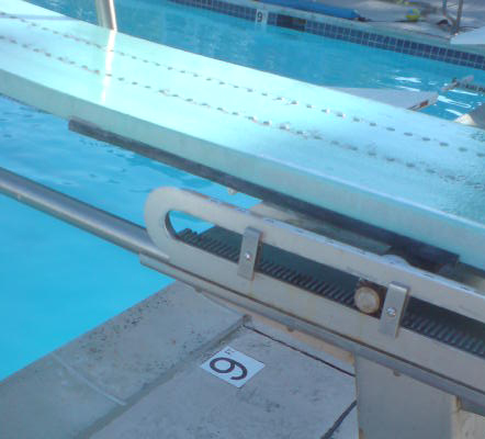 divingboard with only 9 feet water depth under: showing part of a 1 meter diving board with a tile in the pool deck below it saying 9 feet, the water depth under the board
