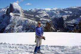 glacierpoint-winter NPS photo: cross-country skier and snow in foreground, peaks, including Half Dome, in background