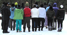 group photo 2012 snow camp: people standing in rows in the snow with their backs turned to the camera