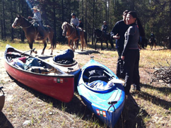 horseback riders and kayakers at Leigh lake portage unknown photographer: a long string of horseback riders, 2 kayakers, 2 kayaks and a canoe