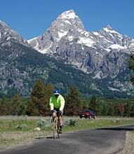 nps photo bike path and peaks: cyclist approaching on paved bike path with peaks in background