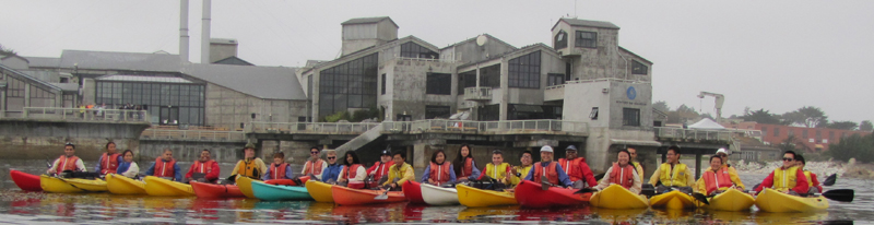 ocean kayak group photo Oct 20 2013 in front of aquarium: row of kayakers in front of the Monterey aquarium