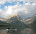 two paddlers on Leigh Lake morning 120 pixels.: two paddlers in a canoe on a lake in the morning with mountains behind