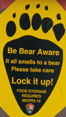 sign be bear aware in shape of footprint: 