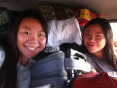 twins in packed car unknown photographer: two girls in the backseat of a car, with gear loaded to the ceiling