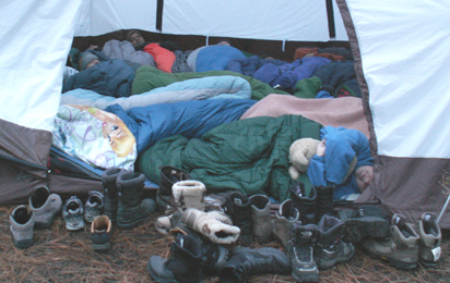 2009 winter trip stuffed in tent: lots of sleeping bags and people in tent, rows of boots outside