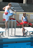 Alanna Klassen and Ethan Wilkie rotate guarding stations 2: one lifeguard climbing up stand ladder while one is on deck level