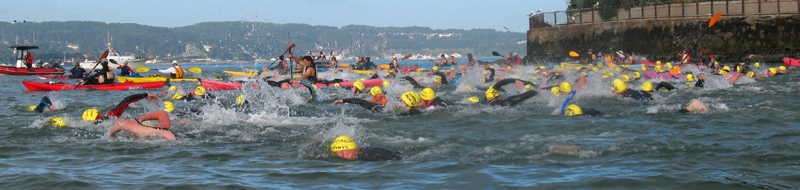 Alcatri start 2010: a mass of swimmers and kayakers on San Francisco bay with part of Alcatraz island in the background