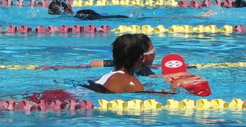 Howard Ho Wai Mok assists swimmer at the Silicon Valley Kids Triathlon: lifeguard helps an athlete finish the swim portion of a triathlon