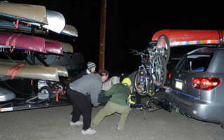 Mila and crew move kayak trailer: people pulling a kayak trailer into posistion to hook it up to a S U V
