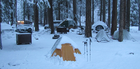 Outdoor club campsite last morning 2011 winter trip: snow covered cars, tents, picnic tables