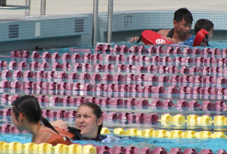 Sierra Anne Janssen and Jonathan Mai assiting triathletes: two distressed swimmers assisted in the water by triathlon lifeguards