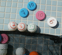 bottle caps and pingpong balls: bottle caps and pingpong balls with numbers written on them