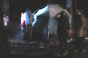 group pitching tent snow camp 2011: group of people pitching tent after dark