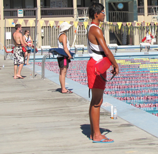 guards on deck at Silicon Valley kids tri: 4 lifeguards at one section of a pool with another lifeguard in the background at the diving well