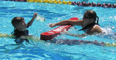 lifeguard approaches distressed child with faulty face mask: lifeguard spots and approaches a young swimmer as he grabs a lane line and holds his face mask in the other hand