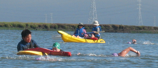 lifeguards at Senior games triathlon Peter Ye rescue board: lifeguards in action at the 2009 summer Senior games triathlon. Peter Ye on a rescue board helping a swimmer and Sherry Fong and Ted Beckman in a kayak.
