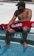 lifeguard sitting at pool edge: 