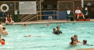 lifeguard at national park pool using rescue tube as a footrest: 