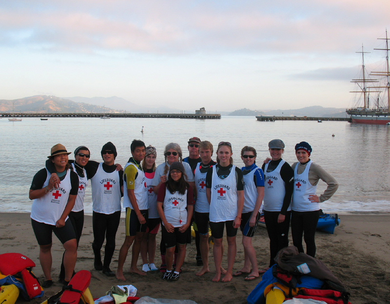 photo by Imelda Terrazas lifeguard group photo Alcatri 2010: lifeguards lined up on the beach at Aquatic Park with sunrise clouds in background