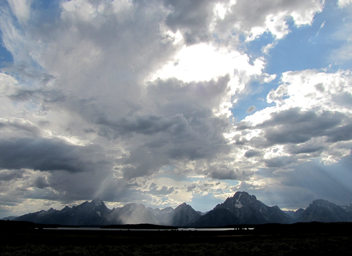 sunlight streaming through clouds teton range Sept 2011: photo mostly of clouds with a mountain range in the distance and little light on a lake in the mid distance