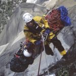 looking down from a helicopter to a rescuer on a basket litter