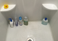 lower half of a shower showing bottles on floorr
