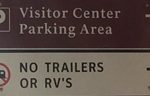 sign that says Visitor Center parking area, no trailers or RVs