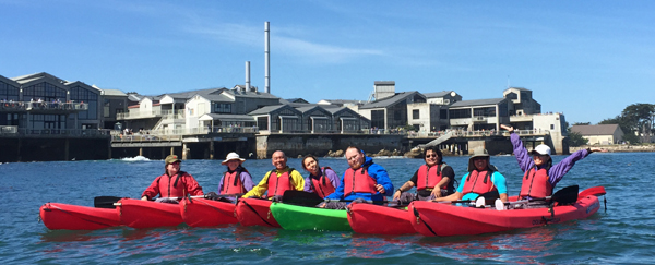 A row of kayaks in front of the Monterey Bay Aquarium