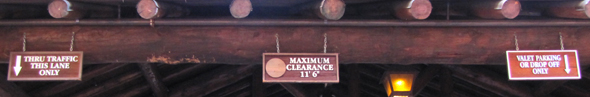 tthree signs along a roof line, one saying maximum clearance 11 foot six inches