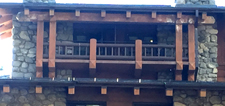 looking up at two balconies with a wooden panel between them