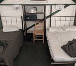 two beds and a chair in a tent cabin