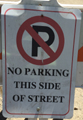 sign that says no parking this side of street