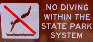  a sign that says no diving within the state park system