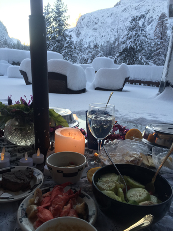 candlelight dinner with snow covered furniture in back ground
