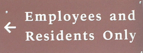 sign with an arrow that says employees and residents only